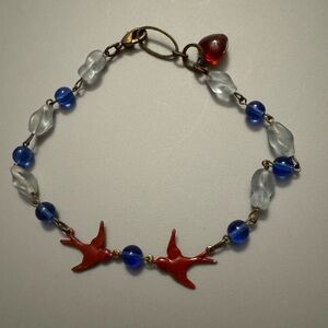 Red birds and blue beads make a bracelet when vintage pieces by hot cakes design